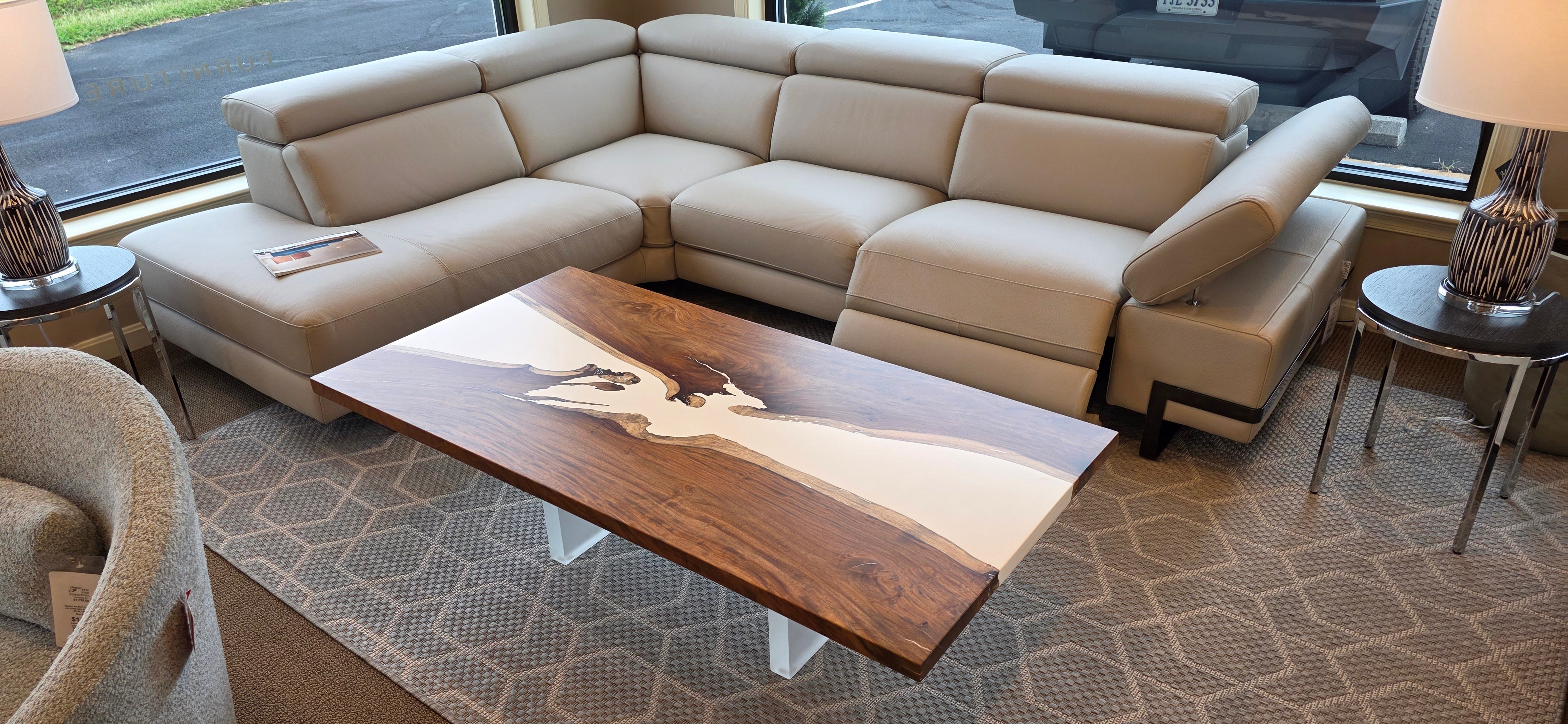 Soberon Studio Ivory River Cocktail Table with richly grained wood and white legs.