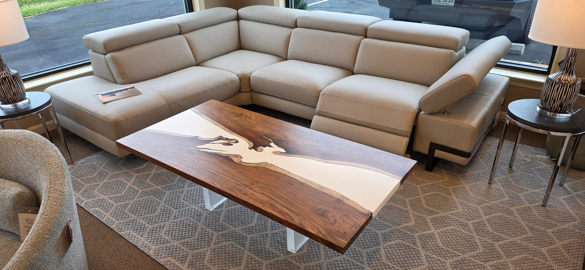 Soberon Studio Ivory River Cocktail Table with richly grained wood and white legs.